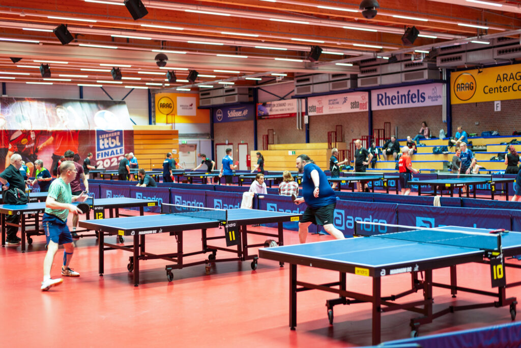 Innenansicht Tischtennis-Halle mit Spielern und Zuschauern auf Tribünen