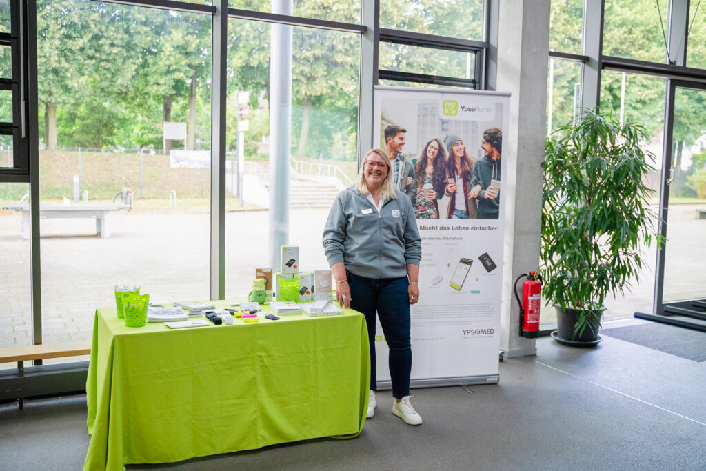 Frau an Messestand mit Informationsmaterial und Broschüren